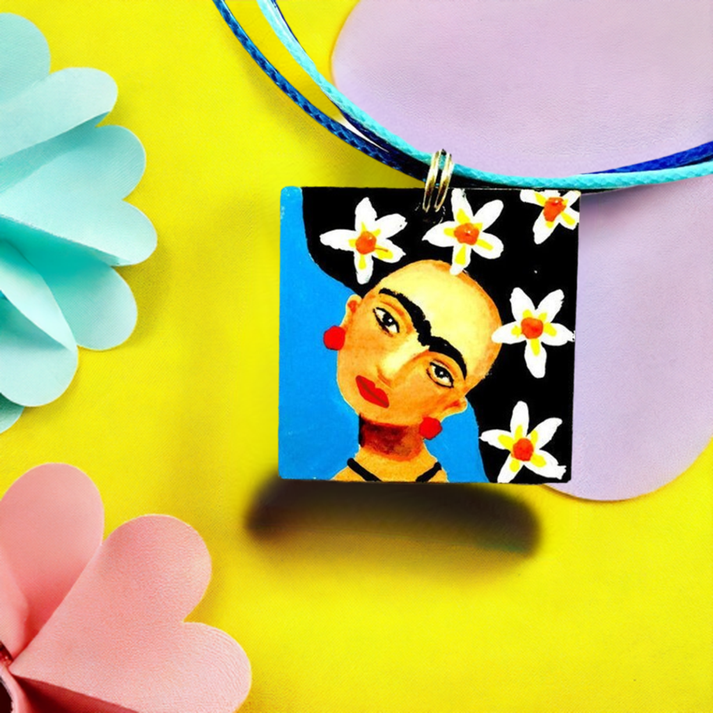 Hand painted Frida Kahlo inspired wooden square pendant with blue background, Mexican artist face with iconic eyebrows, and black hair with white flowers. Cute gift idea for girls. Fridamaniacs. Fridalovers. Mexican earrings. Mexican jewelry. Fridamania