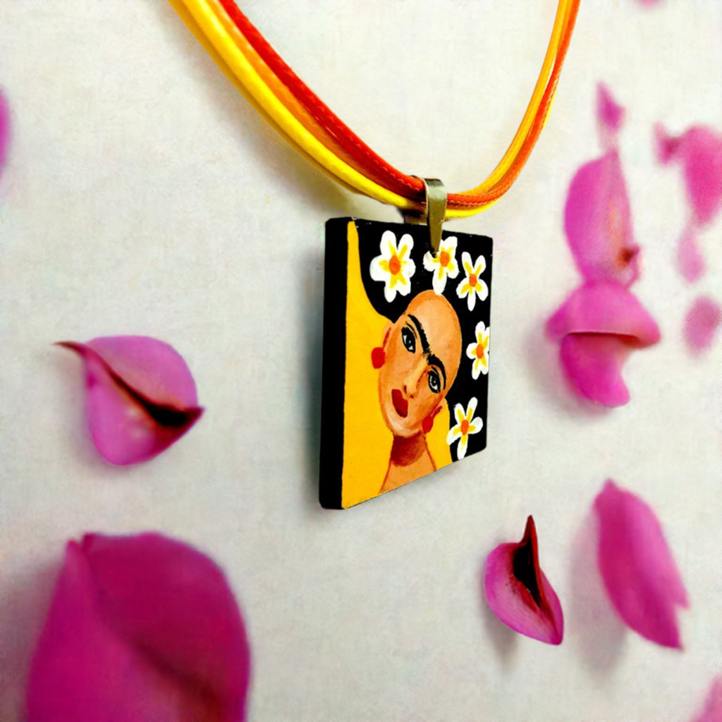 Vivid yellow hand painted Frida kahlo inspired square pendant with multicolored orange tones cords necklace. The painitng shows Frida Kahlo inspired face with iconic eyebrows and flowers. Fridamaniacs, fridalovers, and frida fans gift idea. Girl Mexican jewelry and necklace