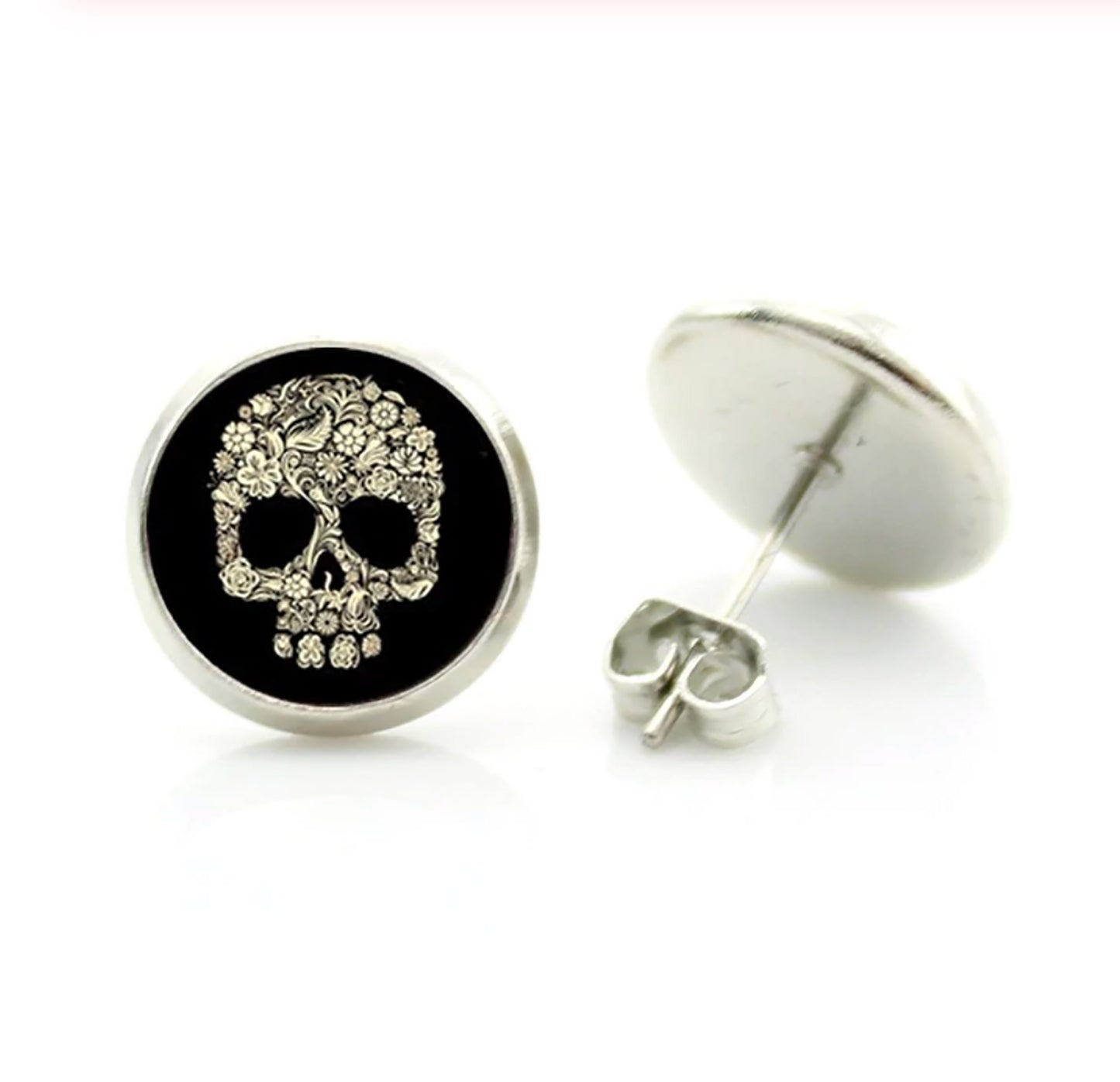 Men's skull stud earrings with dark black and bone color tone designs on silver frame with clear acrylic glass. Man cacochon earrings. Rock, Punk, and Tattoo fashion for man and guys by CALACAMANIA™ accessories.
