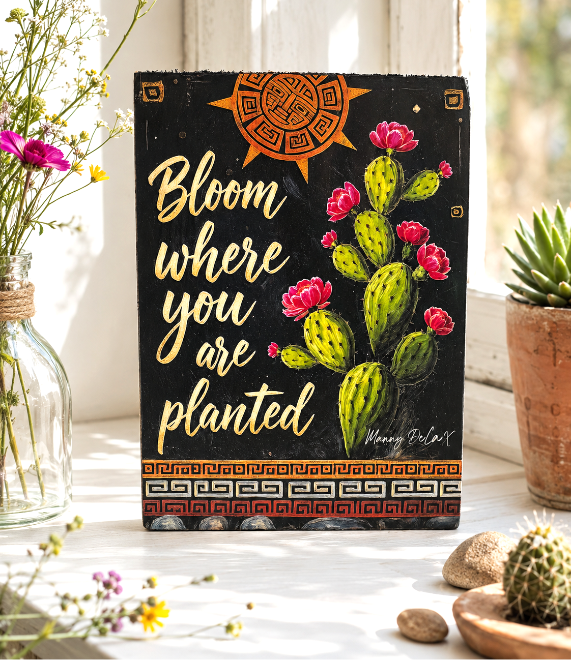 Decorative sign with cactus illustration and motivational quote in a home setting.