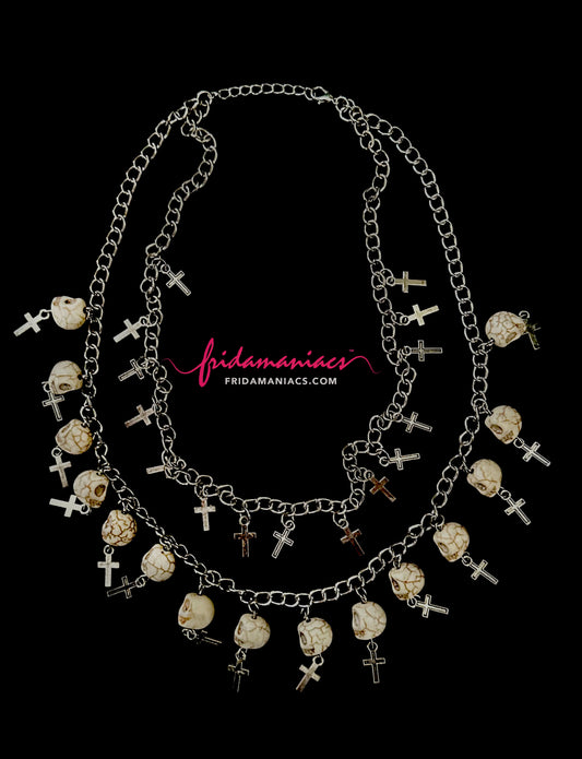 Necklace with skull and cross designs on a black background, featuring the brand 'Frida Maniacs'.