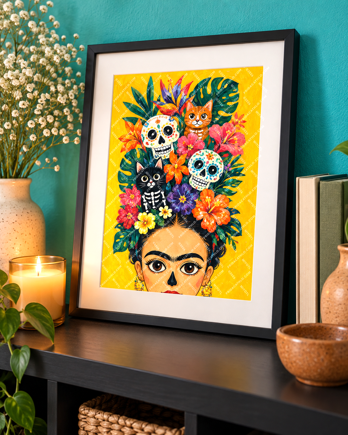 A framed art print featuring a colorful Day of the Dead style portrait with floral hair, sugar skulls, and cat motifs on a bright yellow background, displayed on a shelf in a styled room setting.