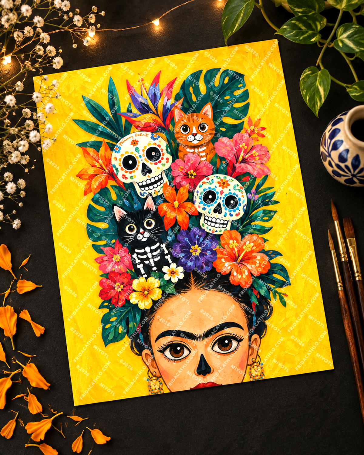 A colorful art print featuring a stylized portrait of Frida Kahlo with flowers and skulls in her hair, surrounded by decorative props including flowers, leaves, string lights, and paintbrushes on a dark surface.