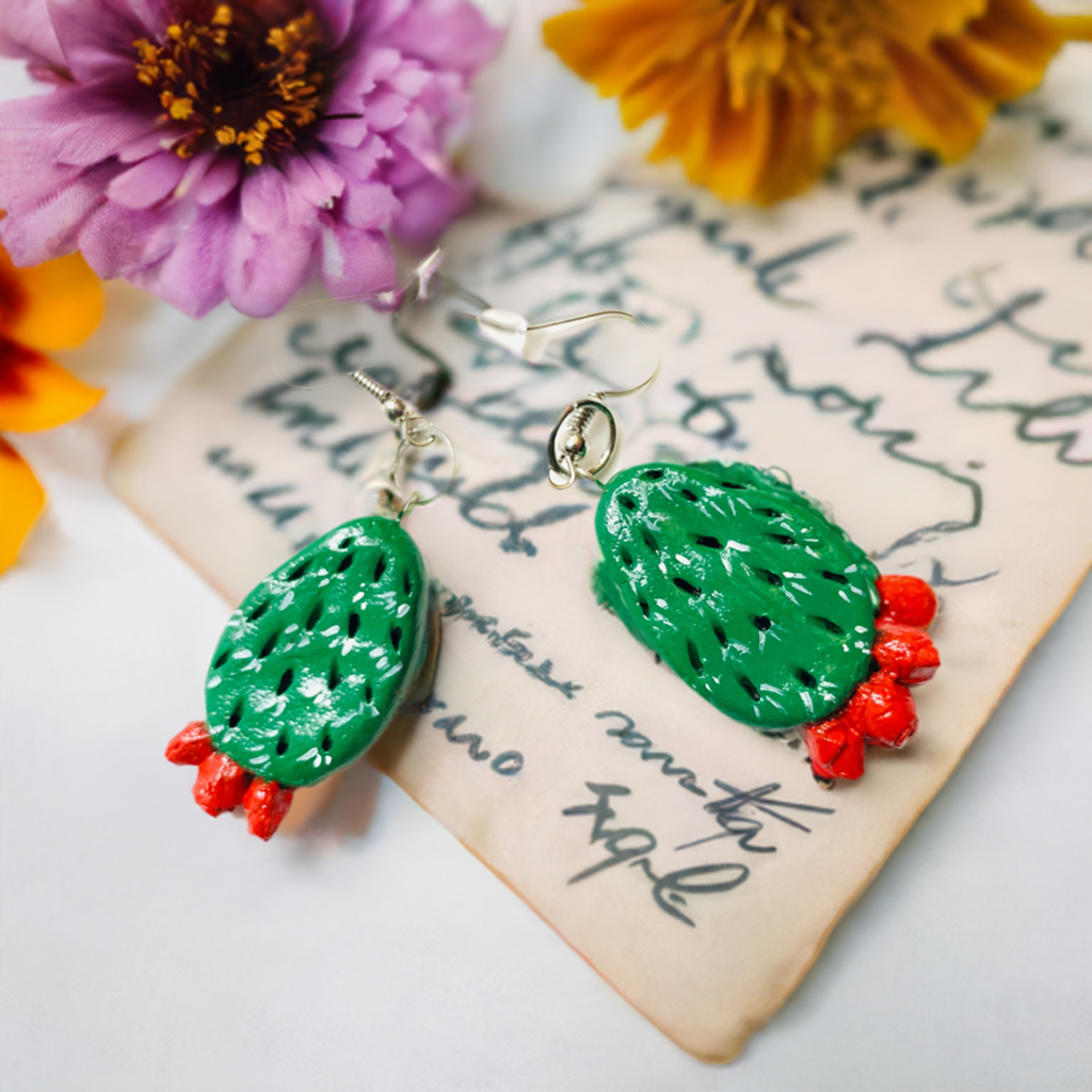 Artisan carved cactus clay earrings painted by hand by Mexican artisans. Fresh green cactus featuring vivid fire red desert cactus flowers. Mexican earrings. Mexico jewelry folk art. Frida Kahlo gift idea for women and girls. Mexicanias. Frida fans jewelry. Fridamaniacs. Fridalovers. Fridamania.