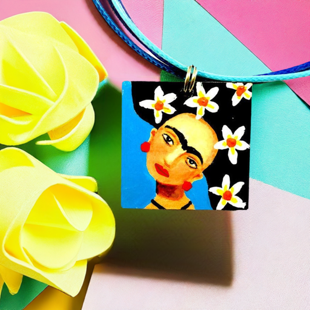 Hand painted Frida Kahlo inspired wooden square pendant with blue background, Mexican artist face with iconic eyebrows, and black hair with white flowers. Cute gift idea for girls. Fridamaniacs. Fridalovers. Mexican earrings. Mexican jewelry. Fridamania