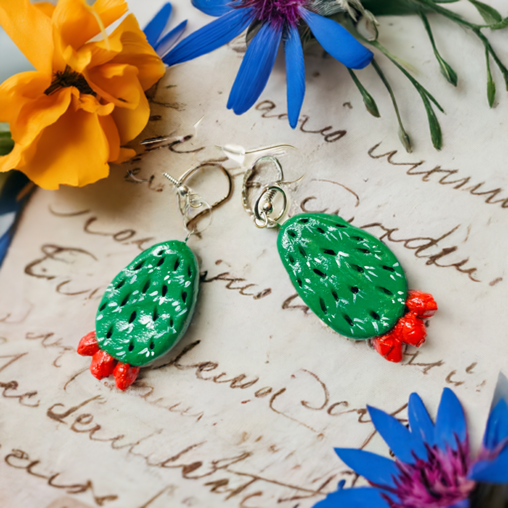 Artisan carved cactus clay earrings painted by hand by Mexican artisans. Fresh green cactus featuring vivid fire red desert cactus flowers. Mexican earrings. Mexico jewelry folk art. Frida Kahlo gift idea for women and girls. Mexicanias. Frida fans jewelry. Fridamaniacs. Fridalovers. Fridamania.