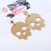 Skull earrings. Metallic gold tone skeleton pendants. Aretes de oro de calavera
